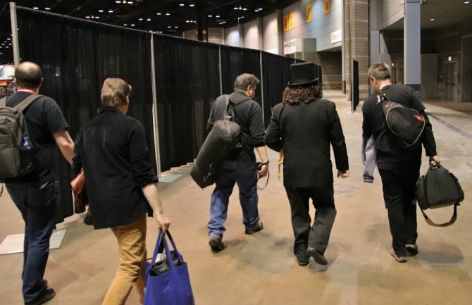 Television horror host, Svengoolie, walks with his film crew through a Chicago convention Svengoolie and crew rush to his Q&A panel